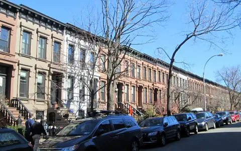 A tree-lined block of row houses in Brooklyn