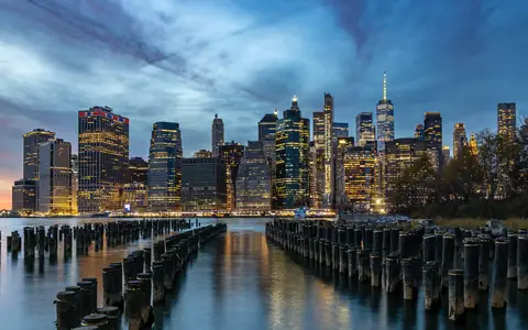 The Lower Manhattan skyline at dusk reflected in the East River