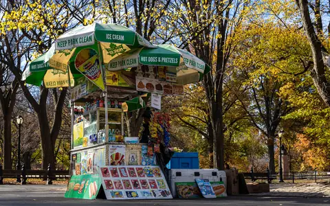 A food cart under autumn trees in Central Park
